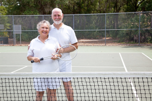 Portrait of active senior couple together on the tennis court.